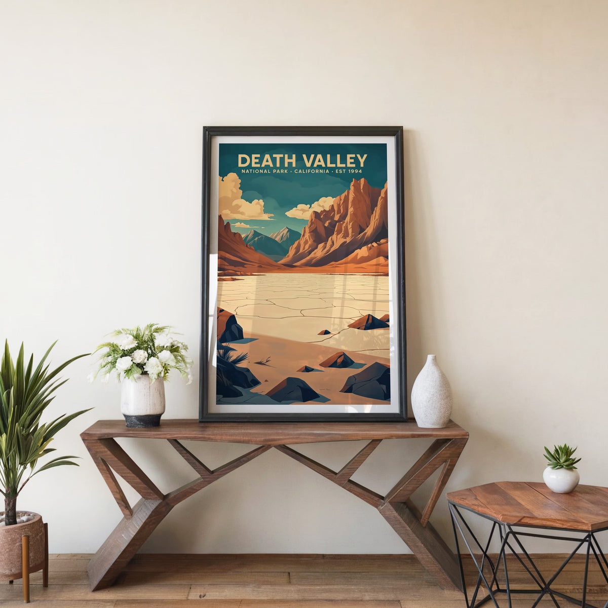 Death Valley poster in a black frame on an entryway console table with white flowers