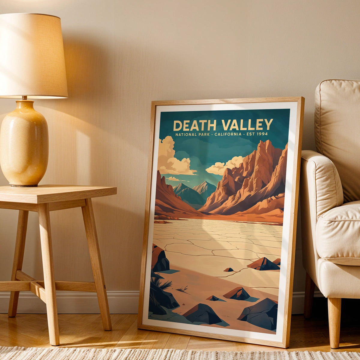 Death Valley print in an oak frame beside a cream armchair and an amber lamp in warm light