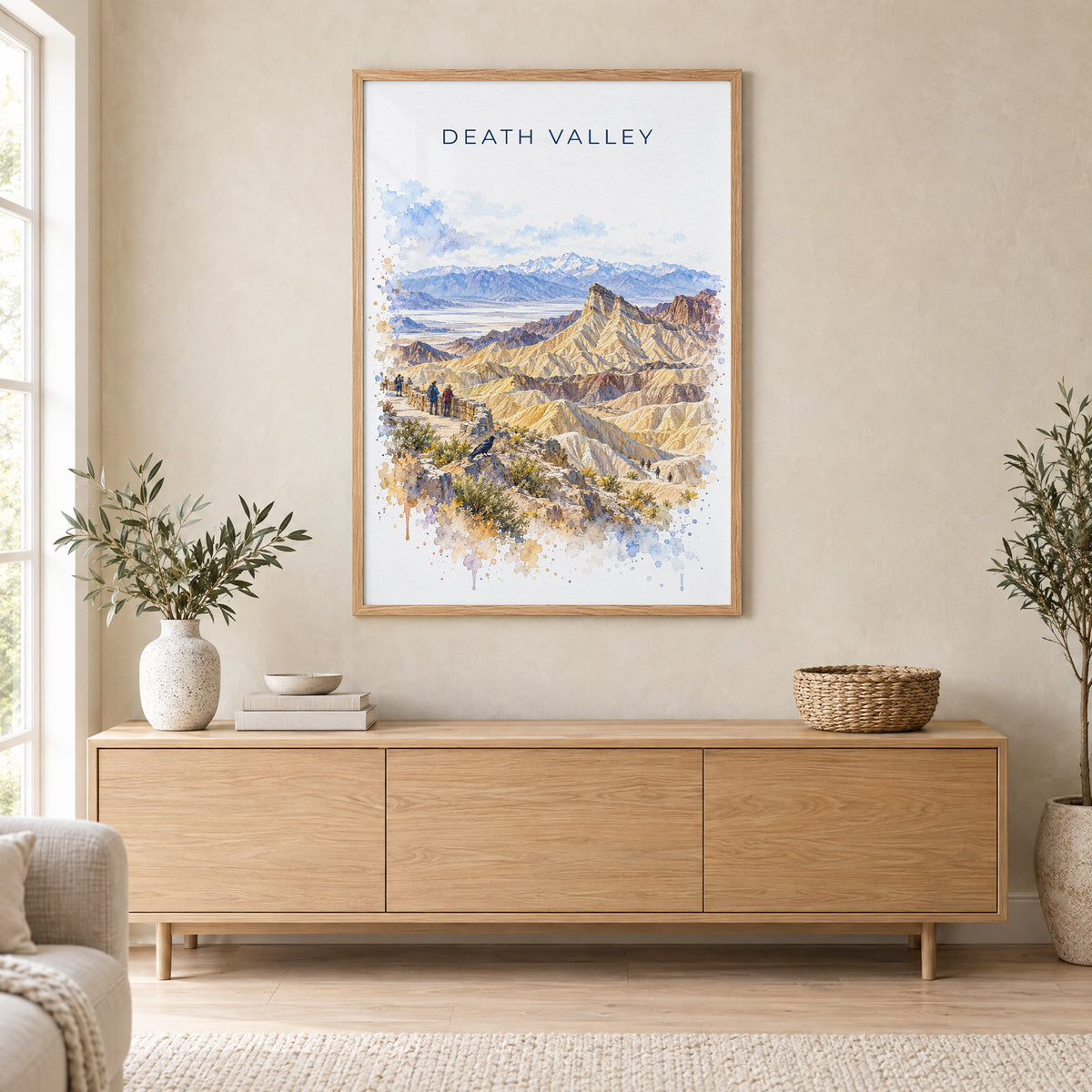 Death Valley National Park watercolor print in an oak frame above a light wood sideboard in a Scandinavian living room