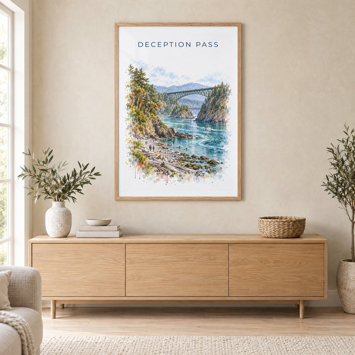 Deception Pass watercolor print in an oak frame above a light wood sideboard in a Scandinavian living room