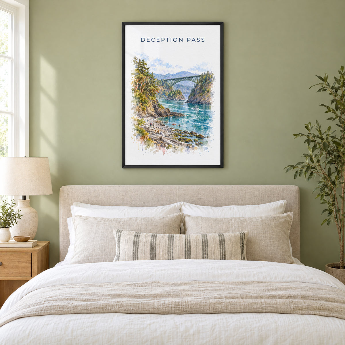 Deception Pass watercolor print in a black frame above an upholstered headboard in a sage green bedroom