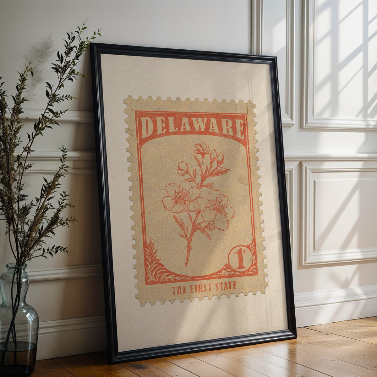 Delaware state flower print in a black frame leaning against a white panelled wall beside olive branches
