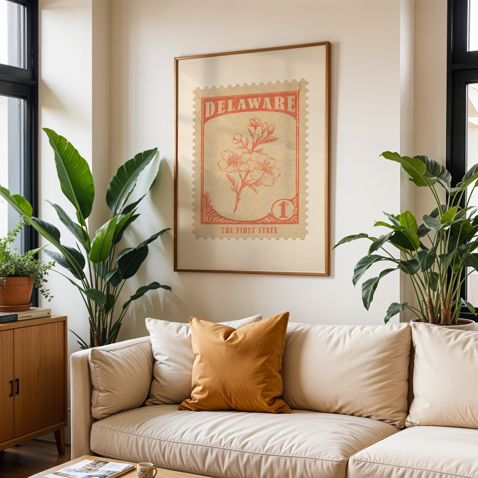 Delaware state flower print framed above a cream sofa with an ochre cushion and large plants either side