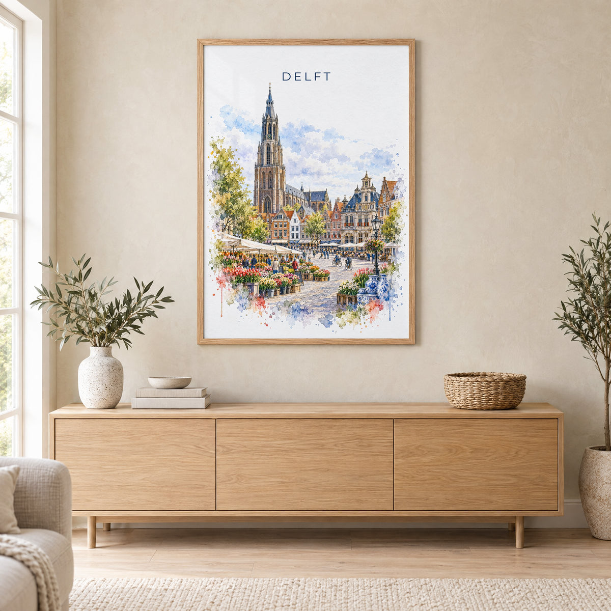 Delft watercolor print in an oak frame above a light wood sideboard in a Scandinavian living room