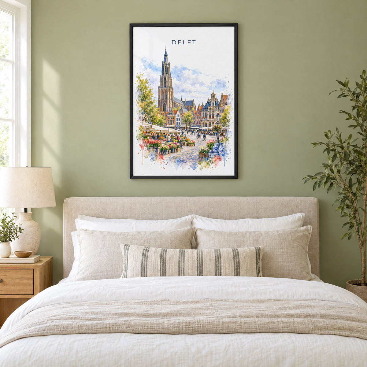 Delft watercolor print in a black frame above an upholstered headboard in a sage green bedroom