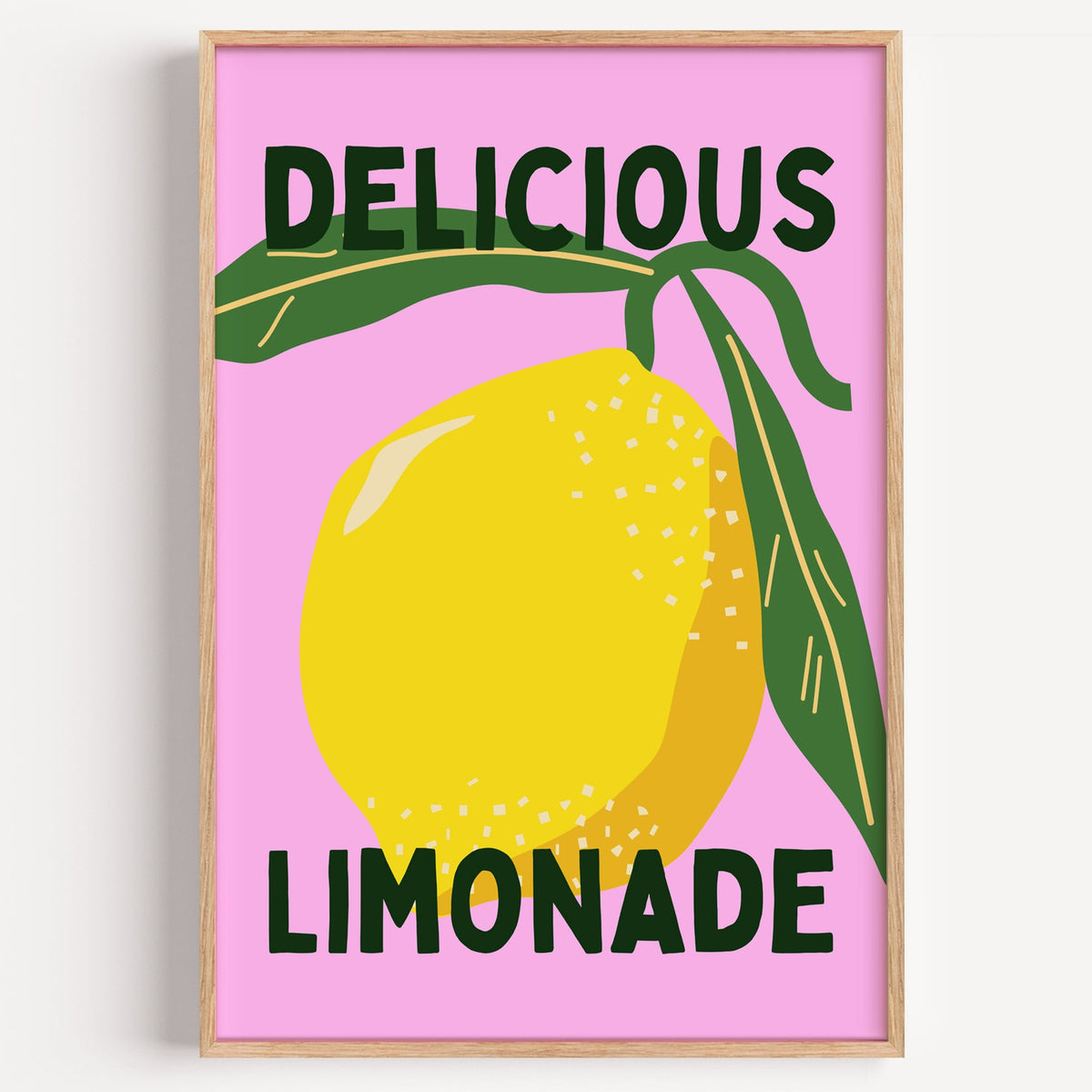 Delicious Limonade pink lemon print in a light oak frame on a plain white wall