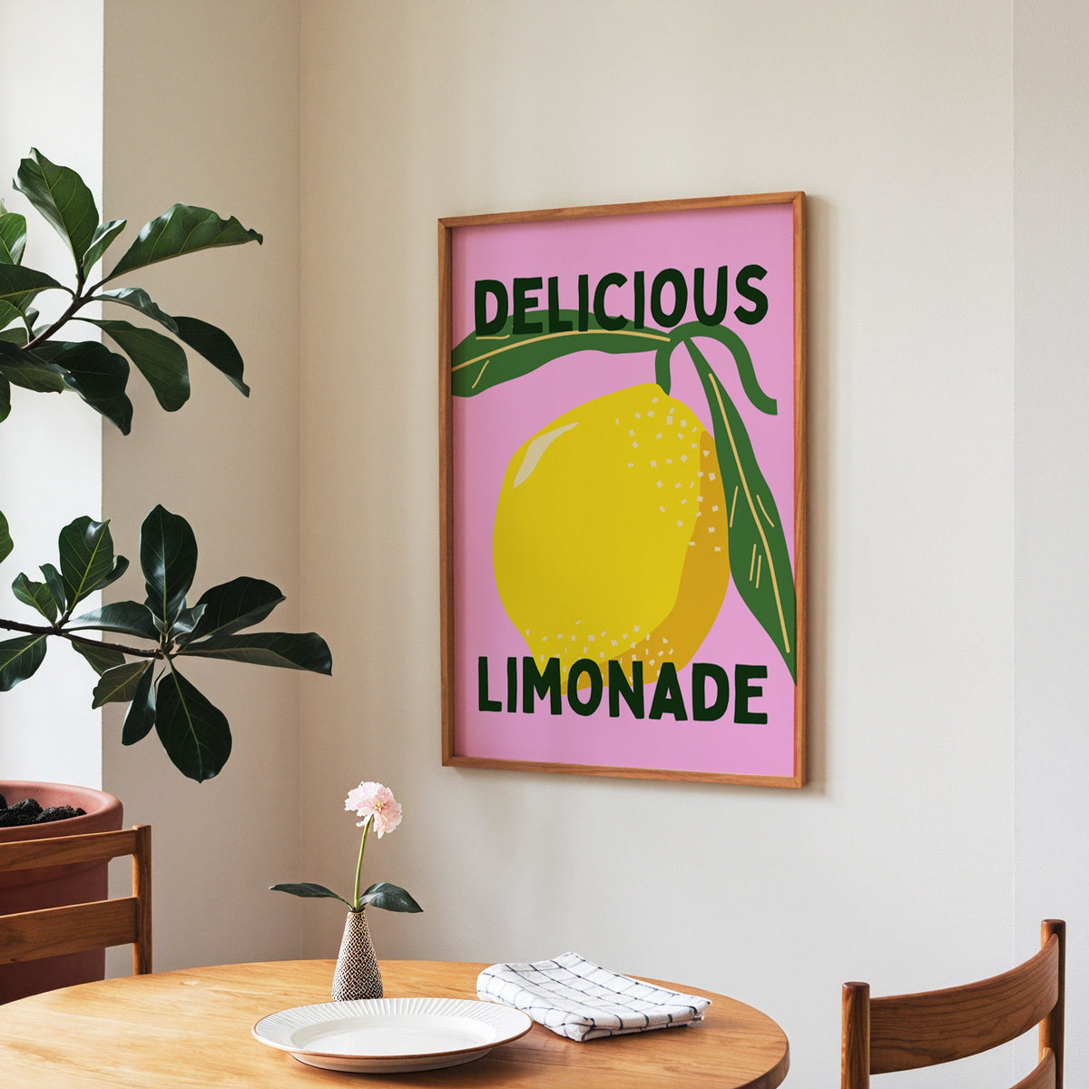 Delicious Limonade print in a walnut frame above a round table beside a fiddle-leaf fig