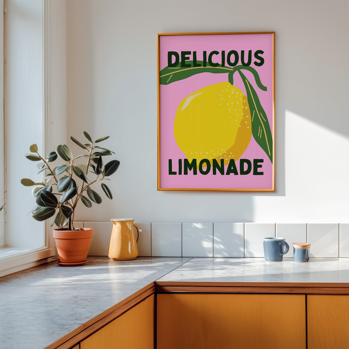 Delicious Limonade print shown in a gold frame above a marble counter in a tan kitchen