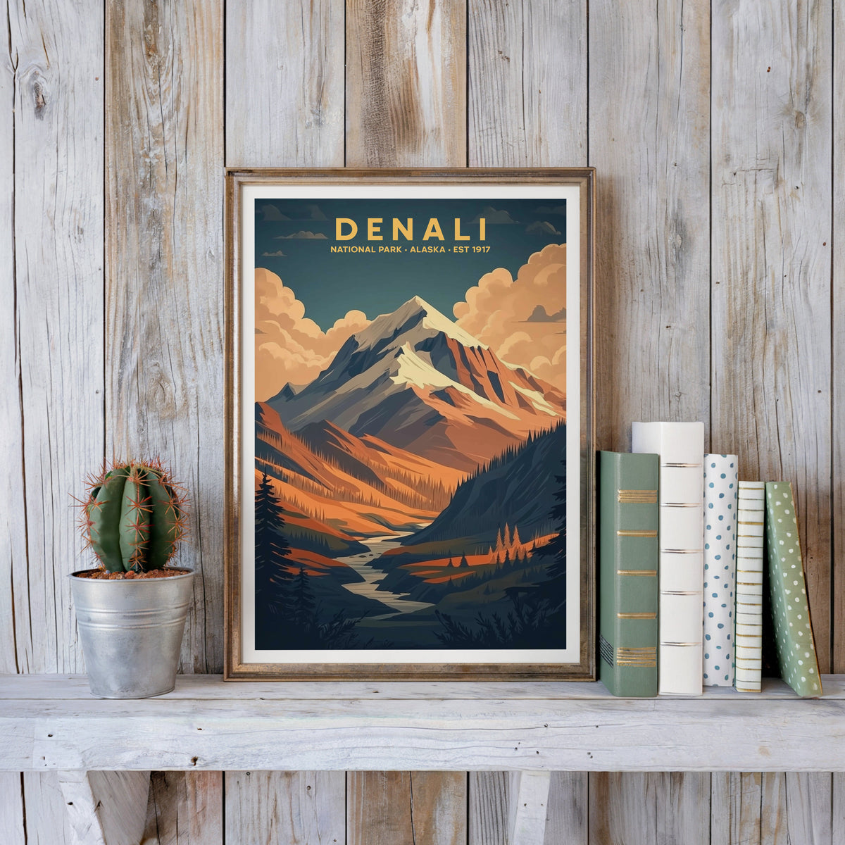 Denali poster in an antique gold frame against whitewashed farmhouse planks beside books