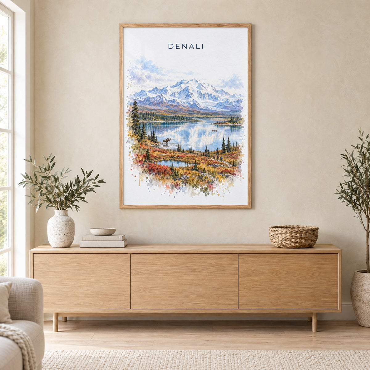 Denali National Park watercolor print in an oak frame above a light wood sideboard in a Scandinavian living room