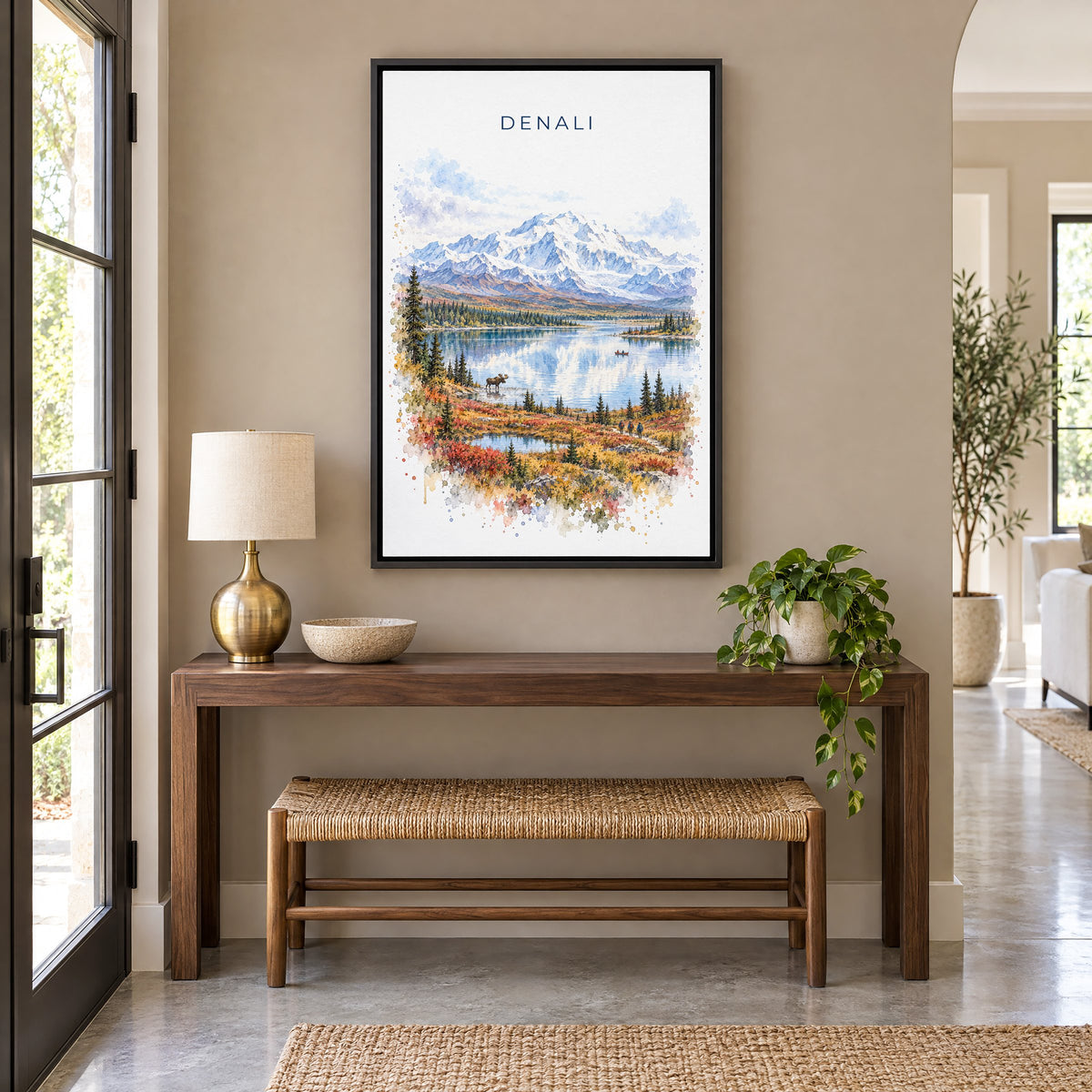 Denali National Park watercolor print as a black floater canvas above a walnut console and woven bench in an entryway