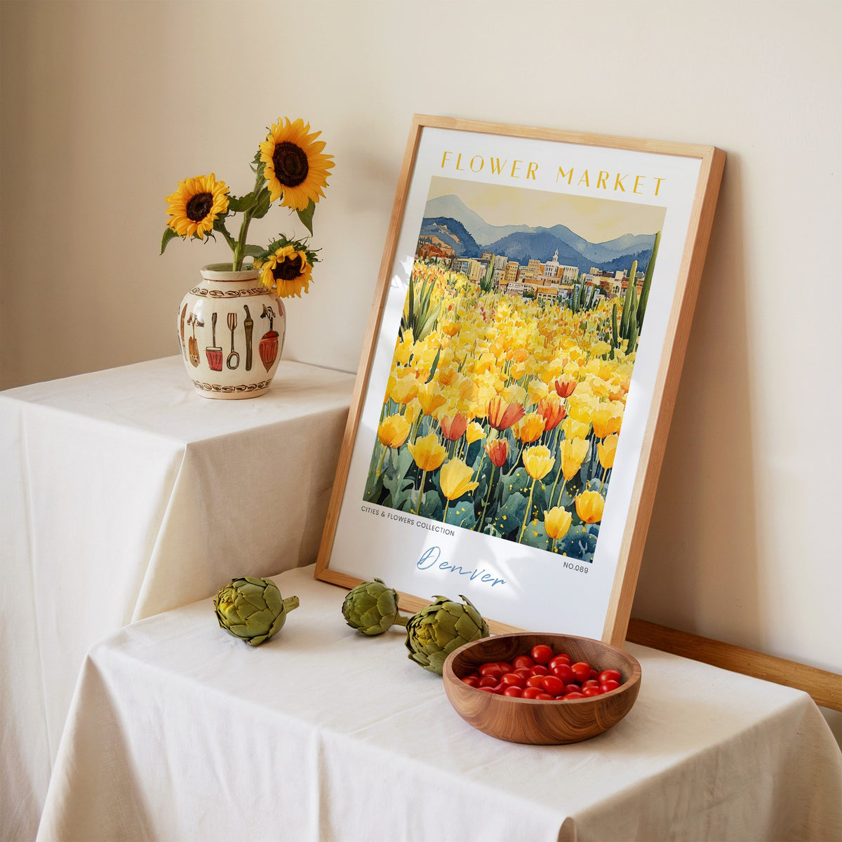 Denver flower market print in an oak frame leaning on a linen-draped table beside a vase of sunflowers