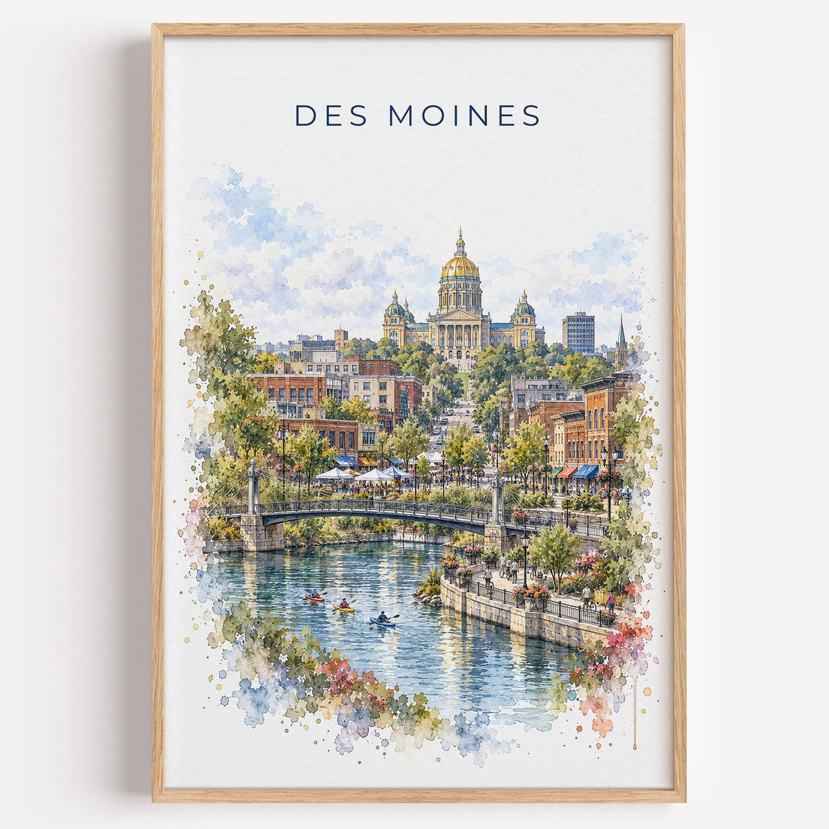 Des Moines watercolor print in a light oak frame on a plain white wall