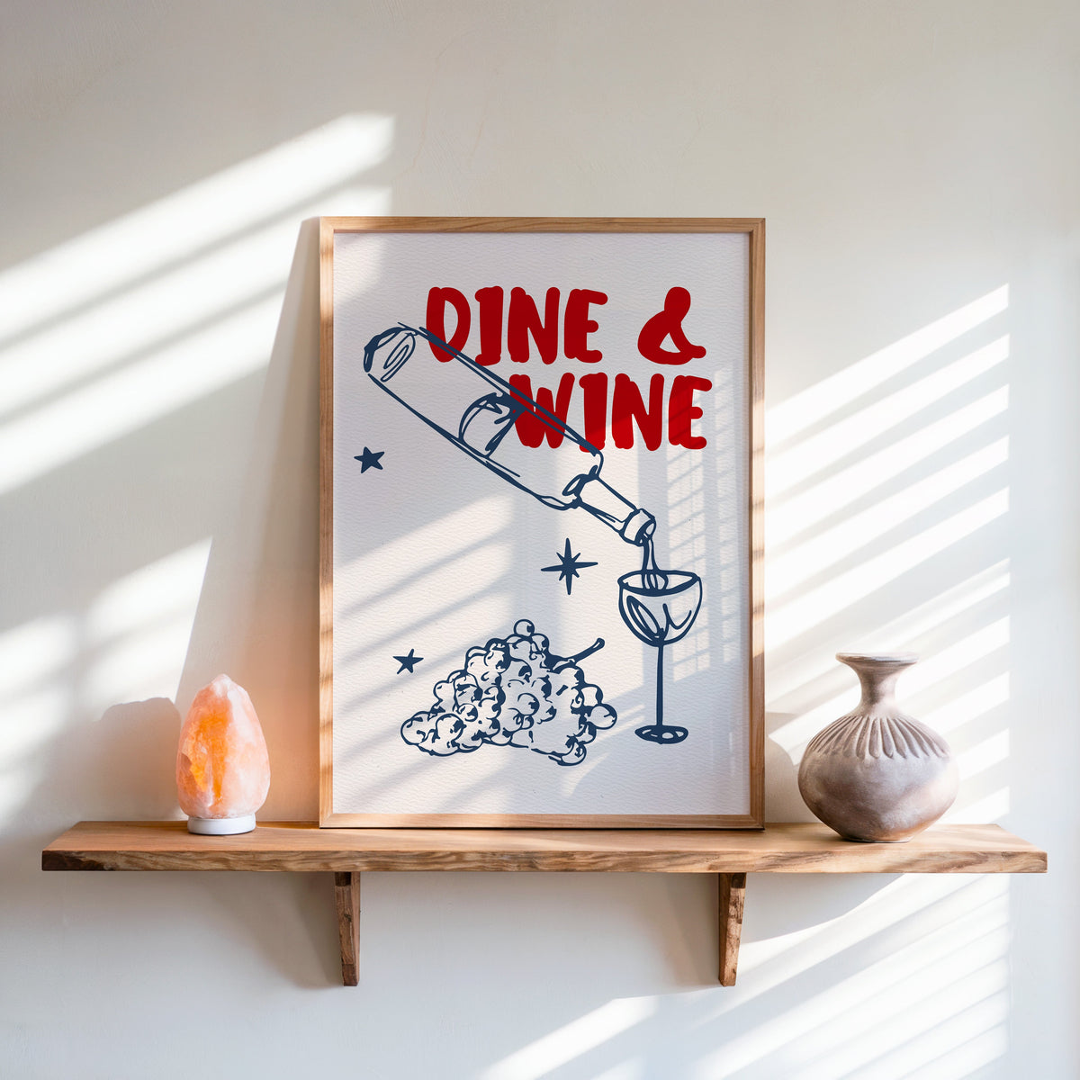 Dine and Wine print in an oak frame on a live-edge shelf beside a salt lamp