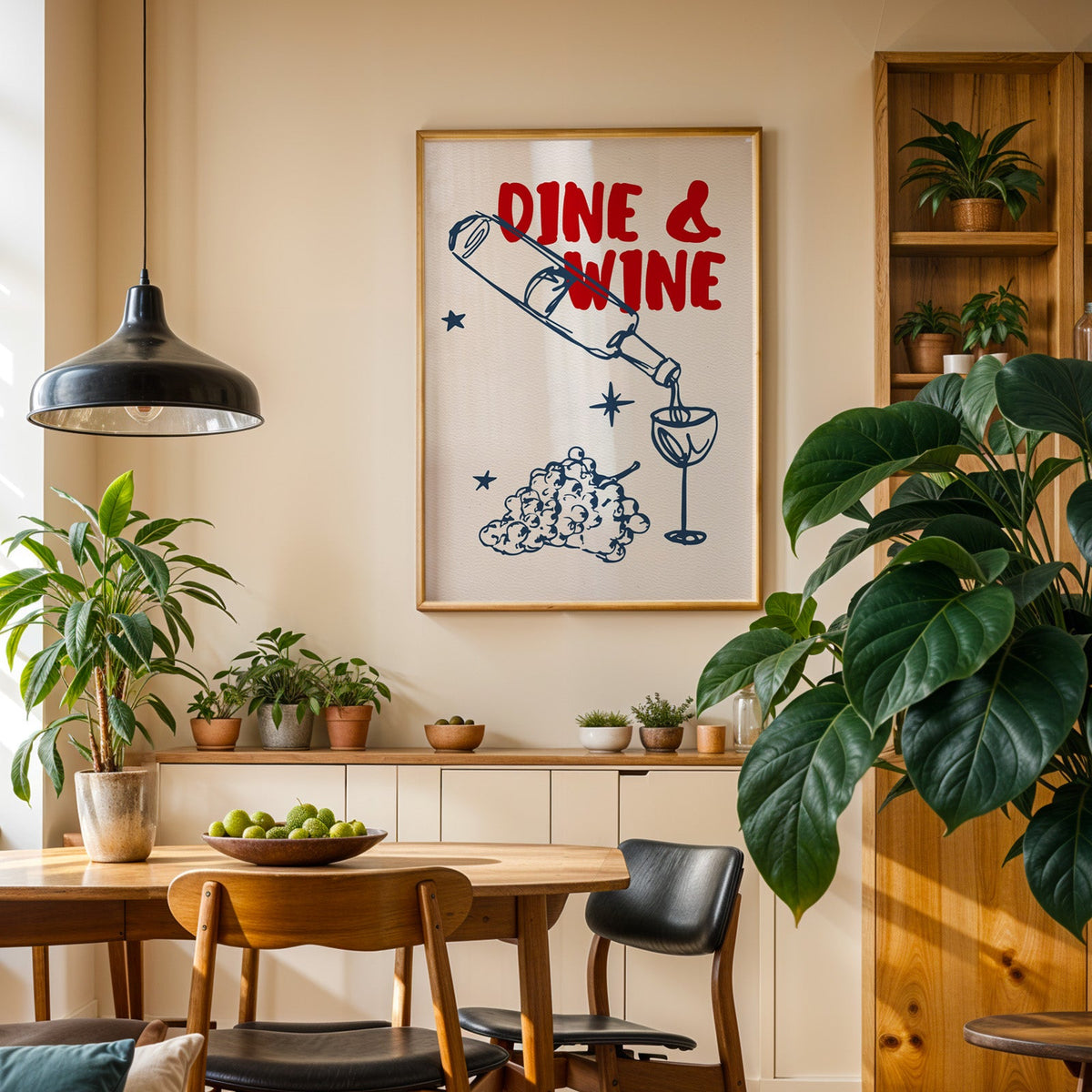 Dine and Wine print in an oak frame in a dining room above a plant-lined sideboard
