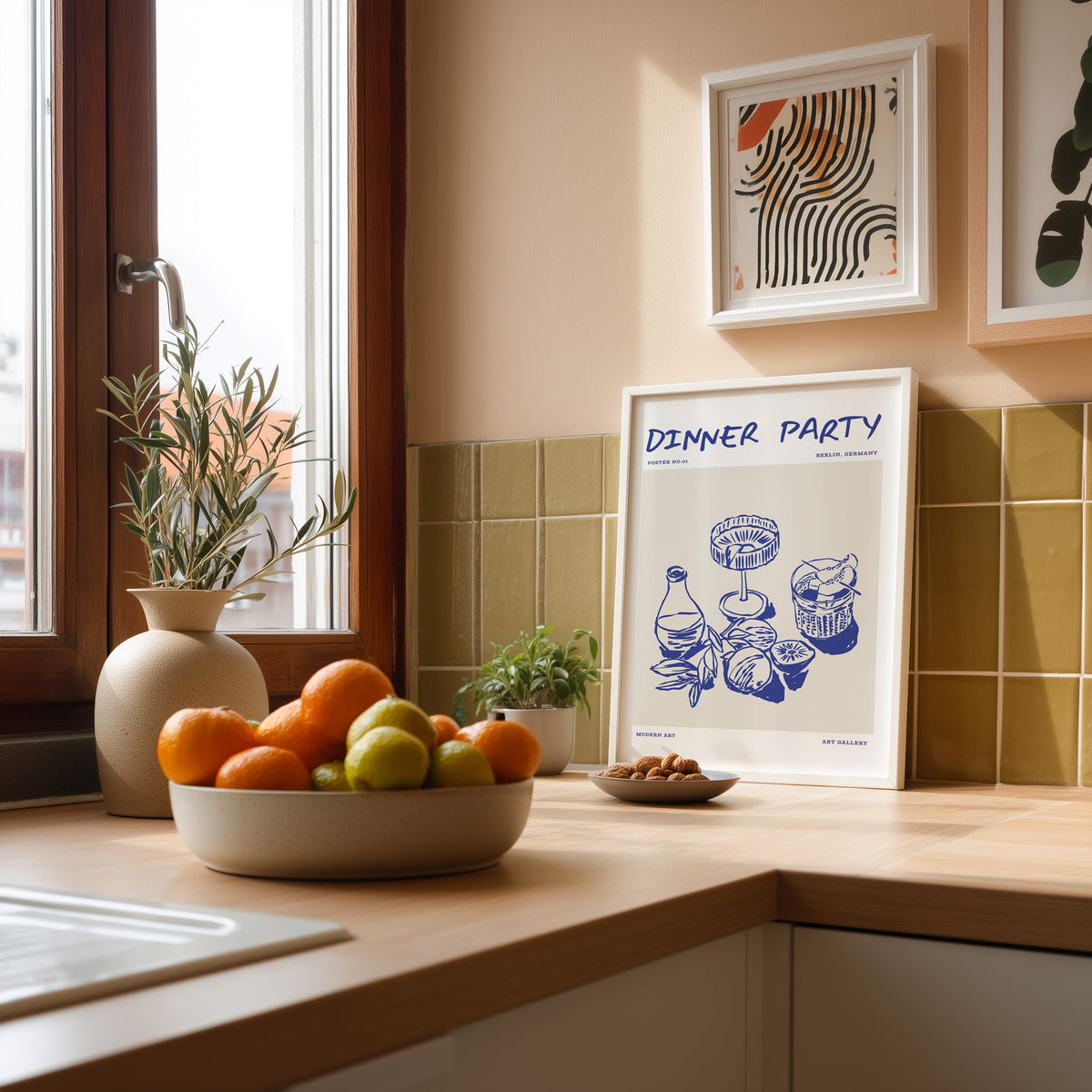 Dinner Party citrus drinks print in a white frame against olive green tiles