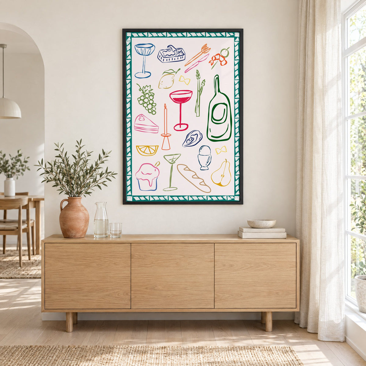Dinner party doodles teal border print in a black frame above an oak sideboard with a terracotta vase of olive branches