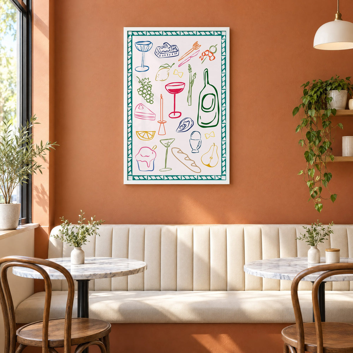 Dinner party doodles teal border print in a white frame above a cream banquette on a terracotta cafe wall