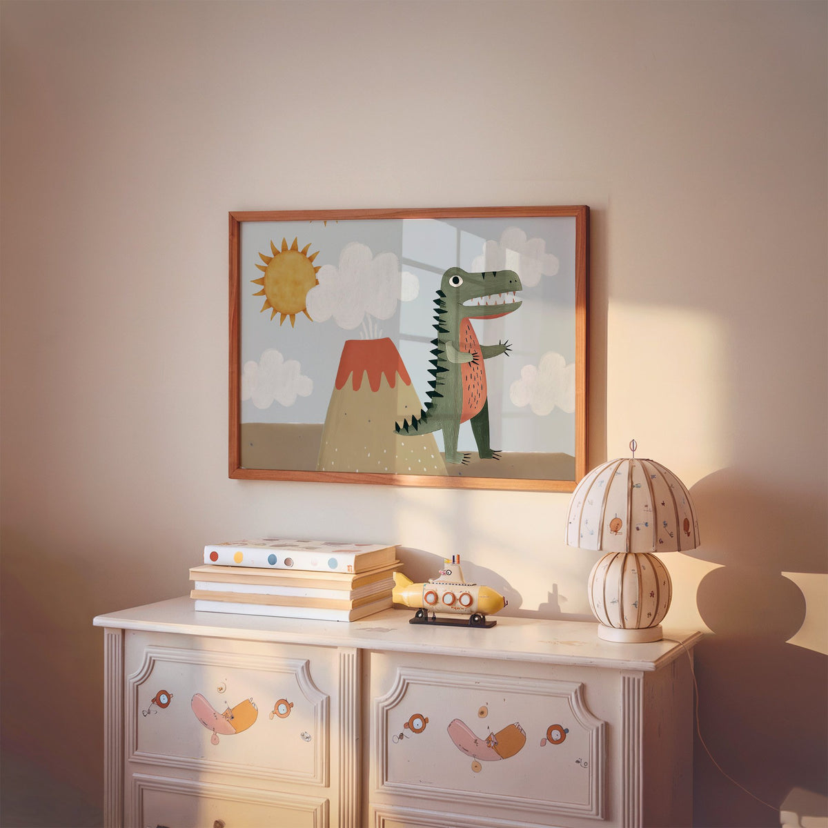 Landscape dinosaur and volcano nursery print in a cherry wood frame above a painted dresser and lamp