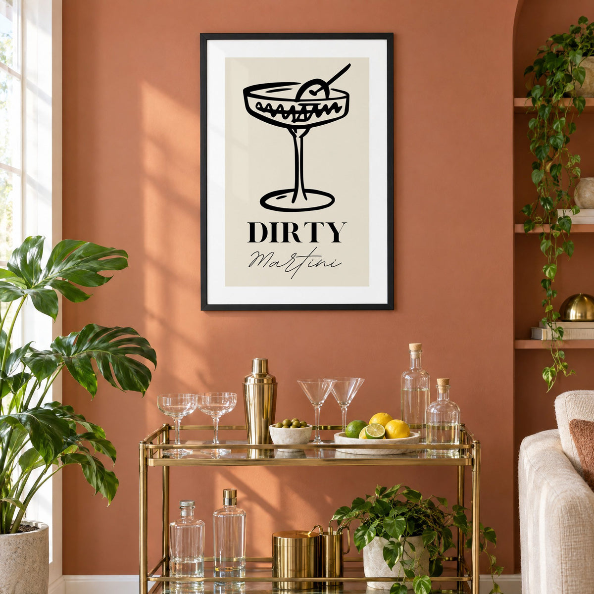 DIRTY Martini black line coupe olive print in a black frame on a terracotta wall above a brass bar cart with coupes and citrus