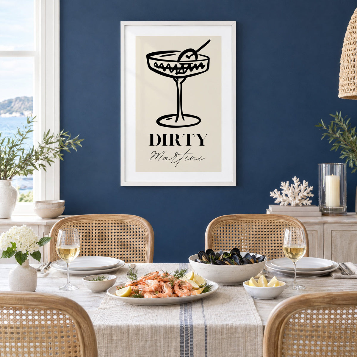 DIRTY Martini black line coupe olive print in a white frame on a navy wall above a dining table set with shrimp and mussels