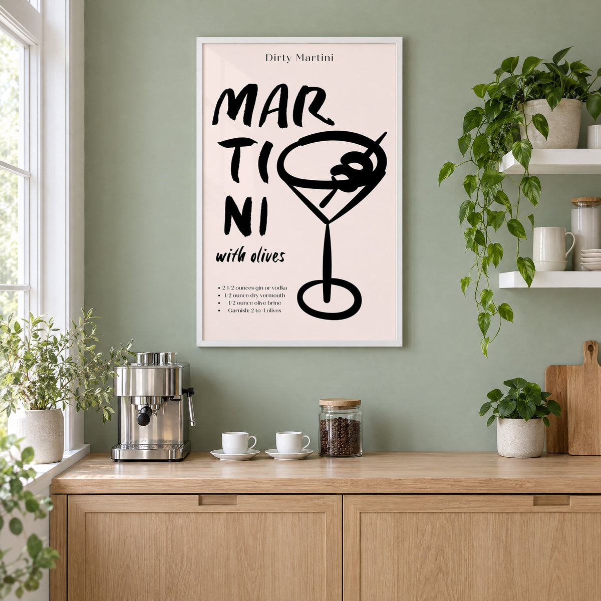 Dirty Martini with olives recipe print in a white frame on a sage green coffee nook wall above an espresso machine