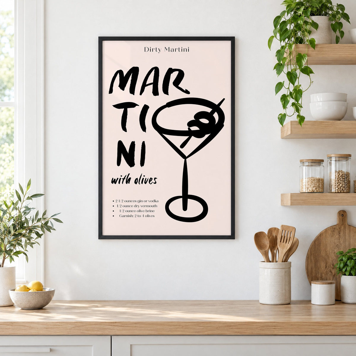 Dirty Martini with olives recipe print in a black frame in a white kitchen beside open wood shelves and glass jars