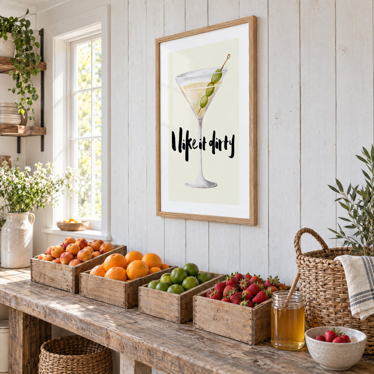 I like it dirty watercolor martini print in an oak frame on white plank walls above wooden crates of fresh fruit, seen at an angle