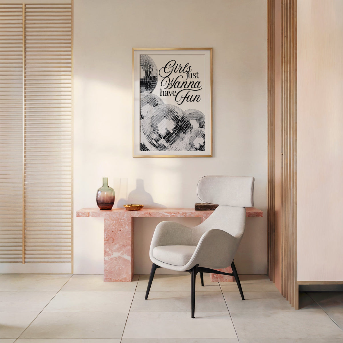 Disco balls with Girls just wanna have fun text print shown in a gold frame above a pink marble console and armchair