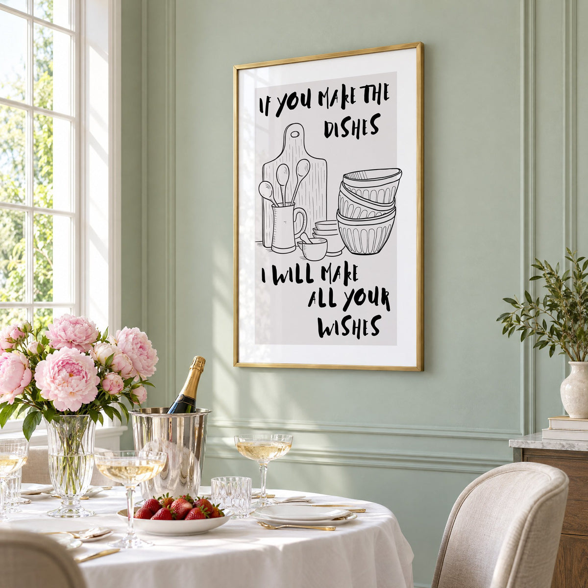 IF YOU MAKE THE DISHES kitchenware sketch print in a brass frame on a sage wall above a brunch table with champagne and peonies, seen at an angle