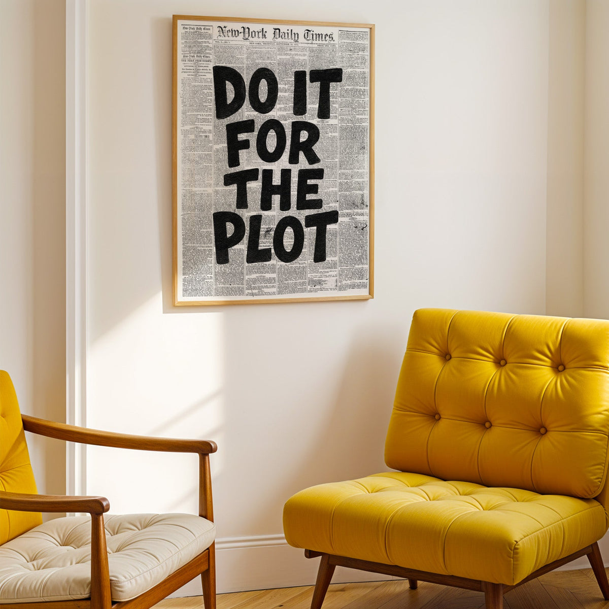 Do It for the Plot black lettering on old newspaper print shown in a gold frame above a mustard yellow tufted armchair