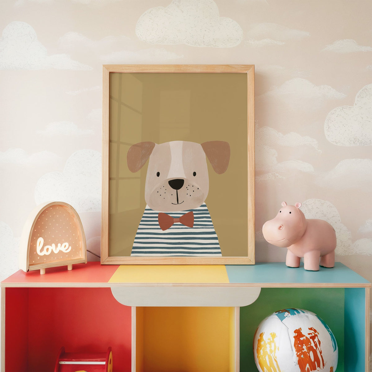 Dog in bow tie portrait nursery print in an oak frame on a rainbow toy shelf against cloud wallpaper