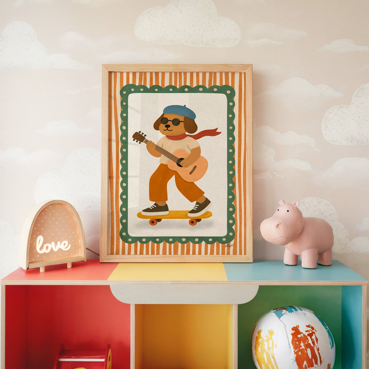Brown dog with guitar on skateboard nursery print in an oak frame on a rainbow toy shelf against cloud wallpaper