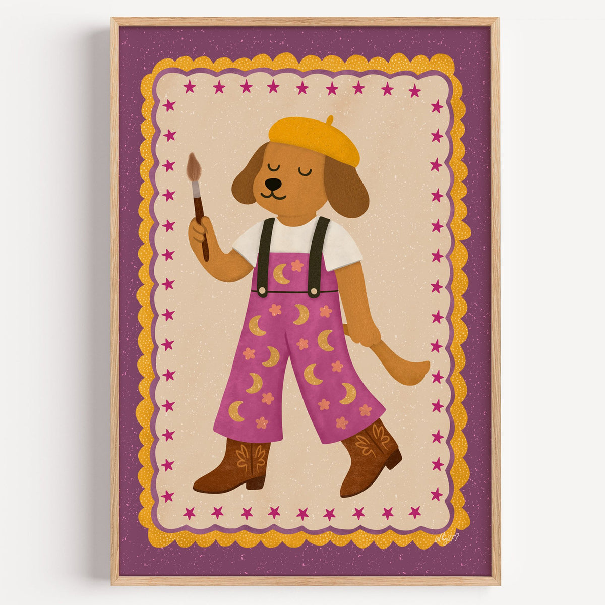 Painter dog in yellow beret nursery print in a light oak frame on a plain white wall
