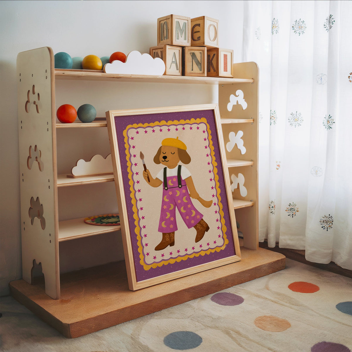 Painter dog in yellow beret nursery print in an oak frame leaning on a toy shelf with wooden letter blocks