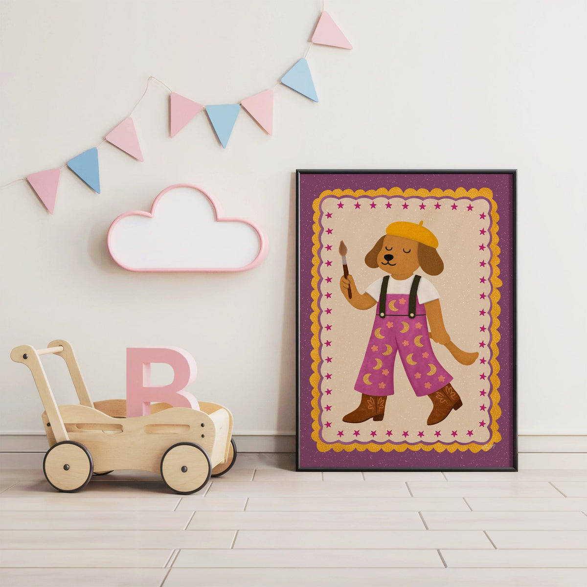Painter dog in yellow beret nursery print in a black frame under pastel bunting by a wooden baby walker
