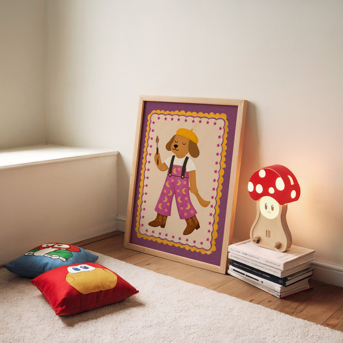 Painter dog in yellow beret nursery print in an oak frame leaning on a rug beside a mushroom lamp and floor cushions