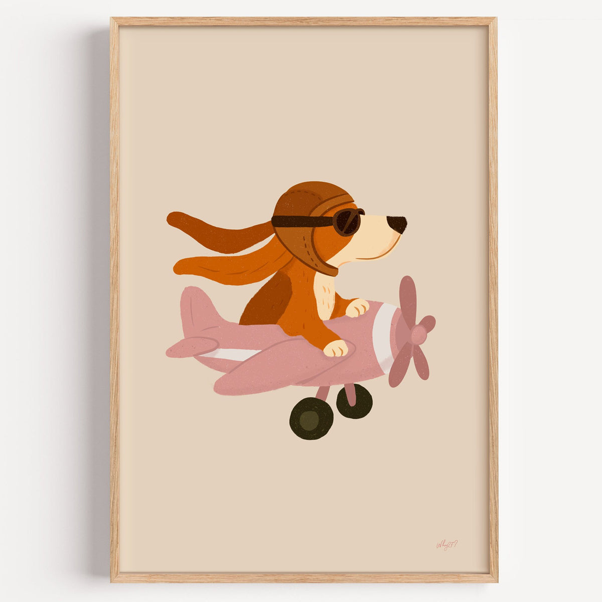 Dog pilot flying pink plane nursery print in a light oak frame on a plain white wall