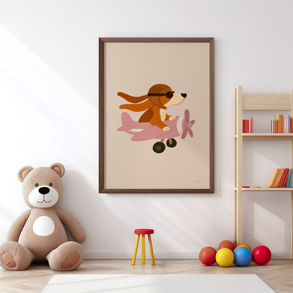 Dog pilot flying pink plane nursery print in a walnut frame above a big teddy bear by a bookshelf