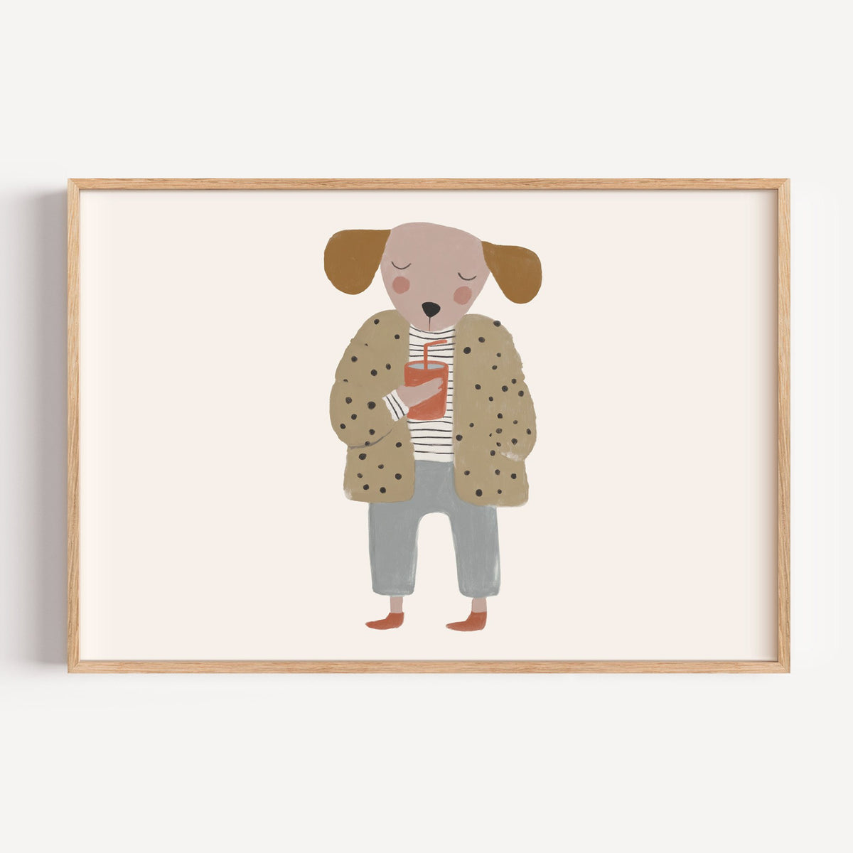 Landscape dog in polka dot coat nursery print in a light oak frame on a plain white wall