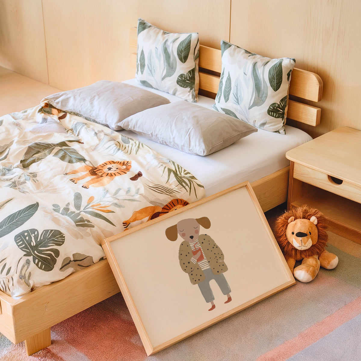 Landscape dog in polka dot coat nursery print in an oak frame leaning on a kids bed by a lion plush