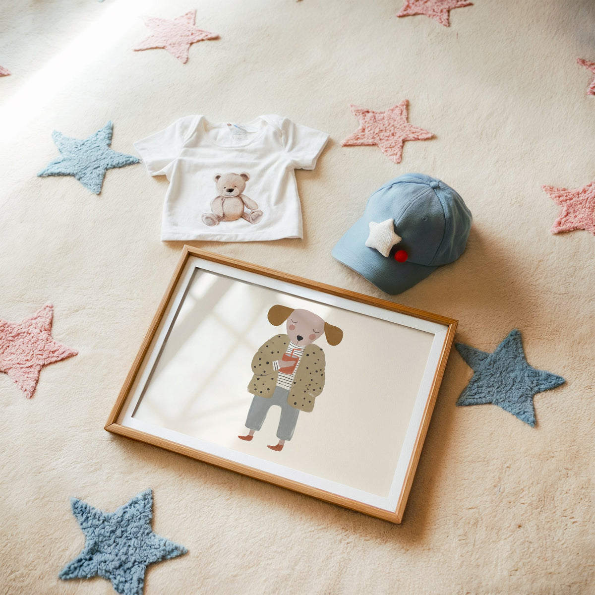 Landscape dog in polka dot coat nursery print in a matted oak frame on a star rug with a baby tee