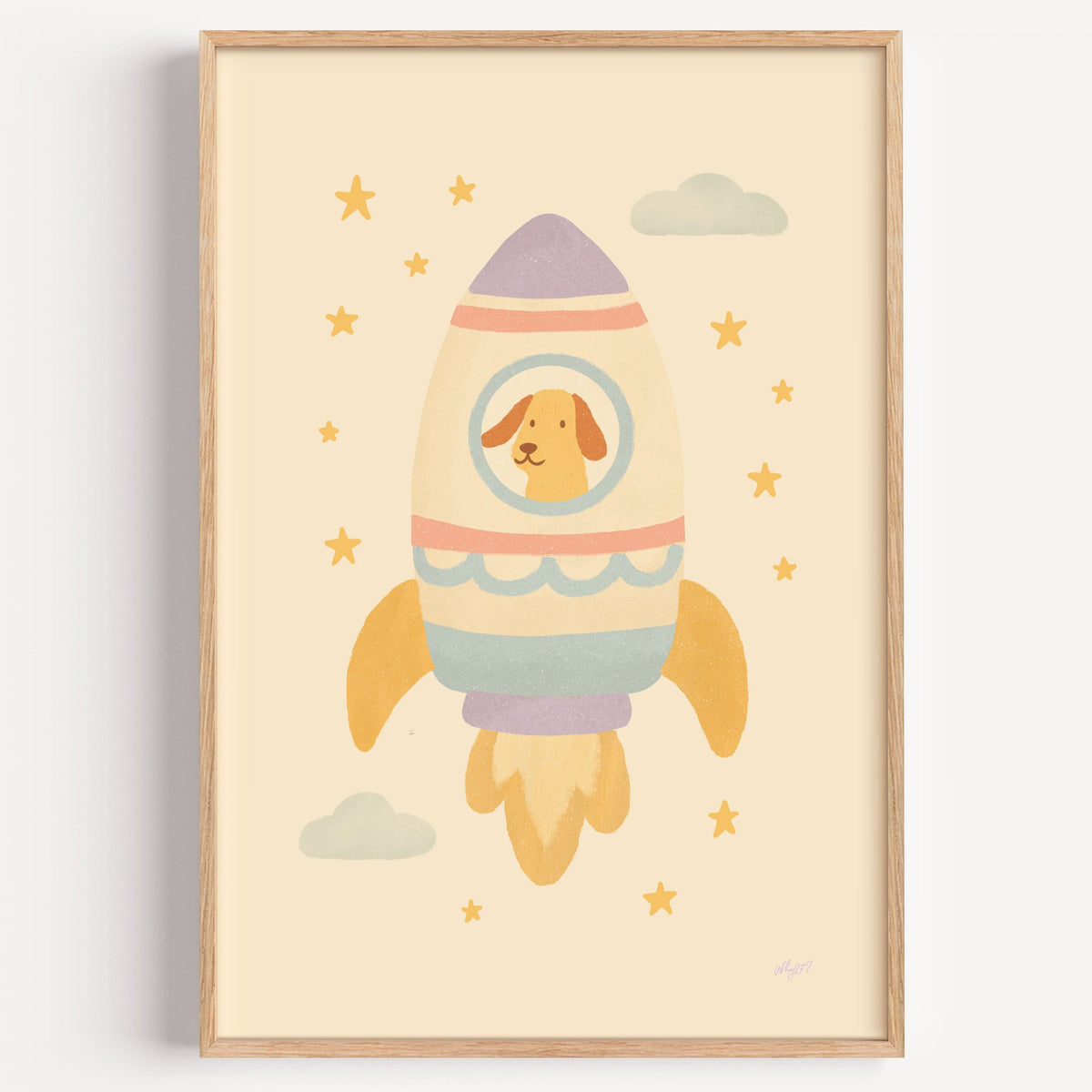 Smiling dog in pastel rocket nursery print in a light oak frame on a plain white wall