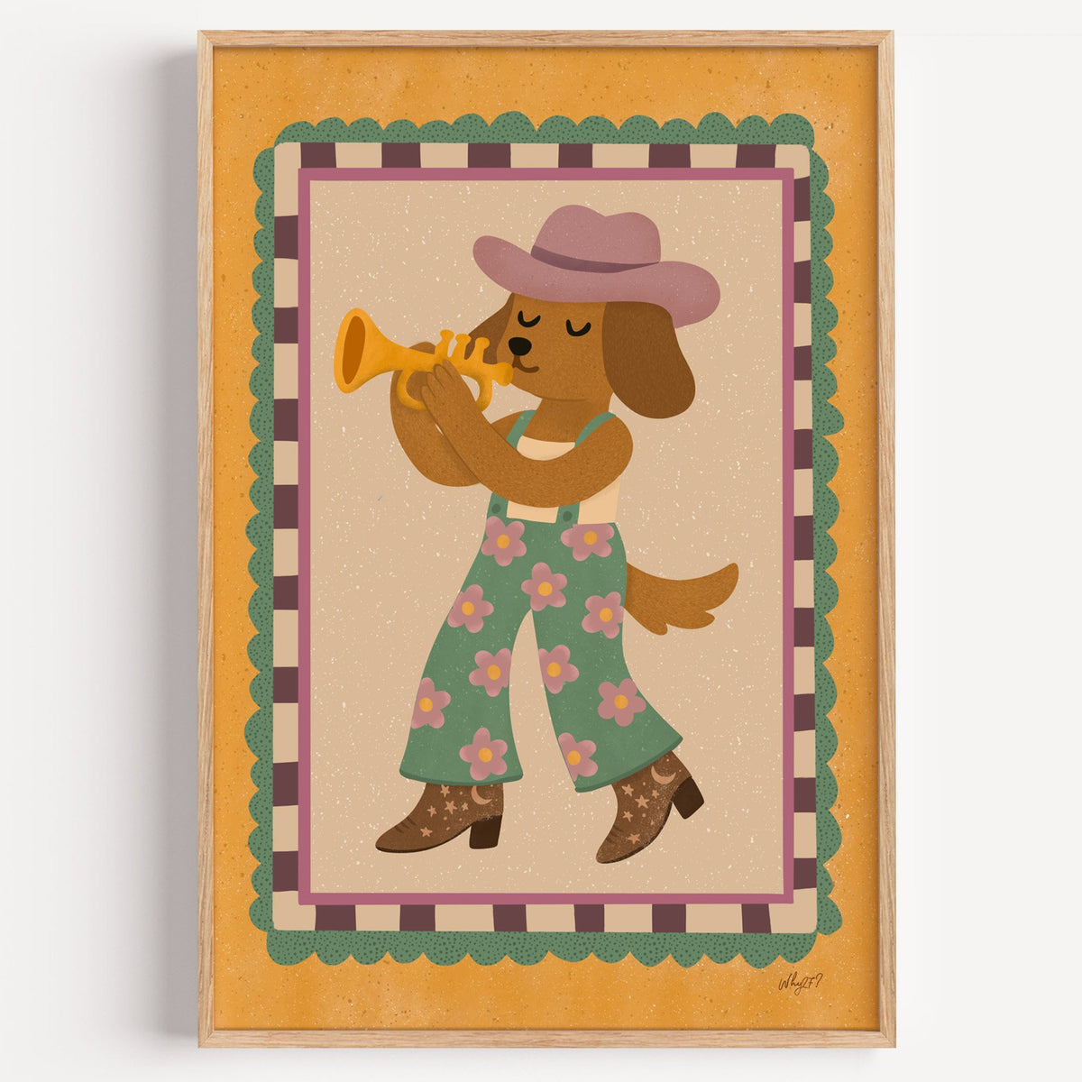 Dog playing trumpet in cowboy hat nursery print in a light oak frame on a plain white wall