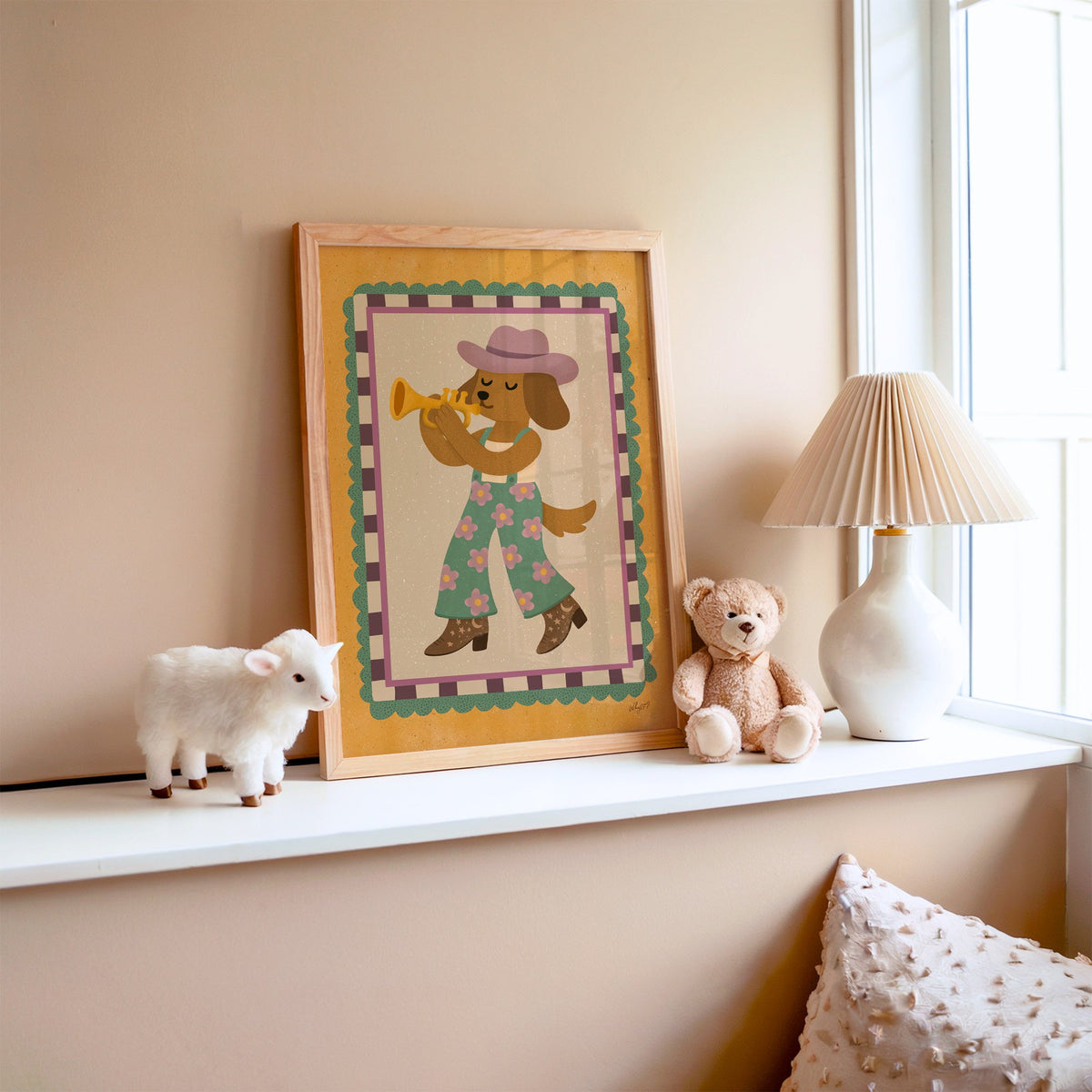 Dog playing trumpet in cowboy hat nursery print in an oak frame on a window ledge with a toy lamb and teddy