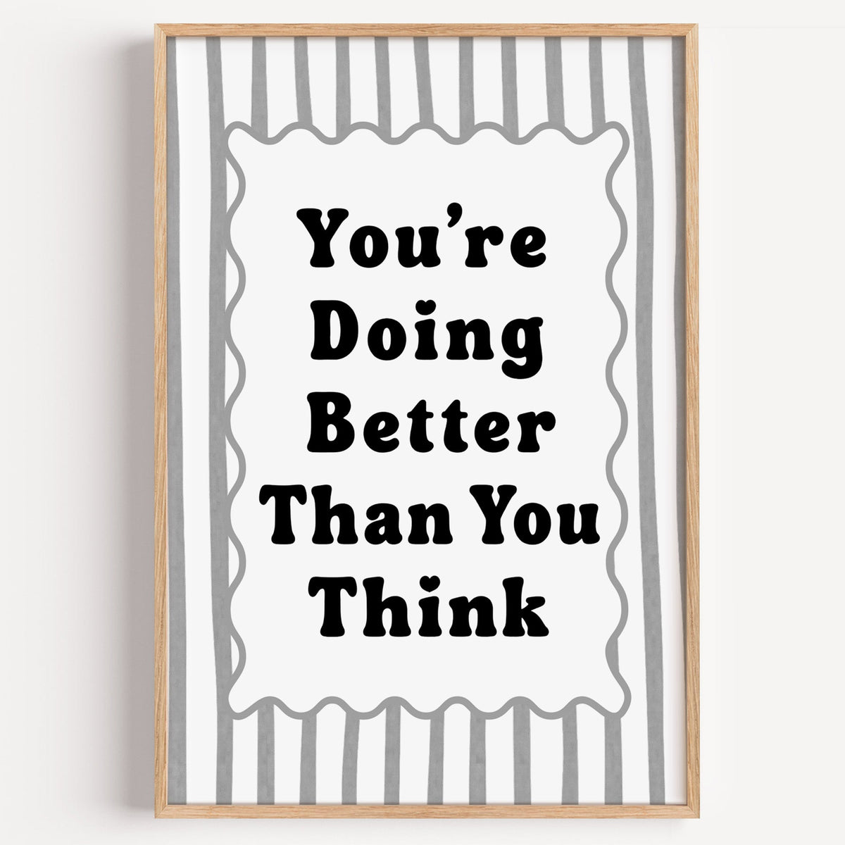 You're doing better than you think striped quote print in a light oak frame on a plain white wall