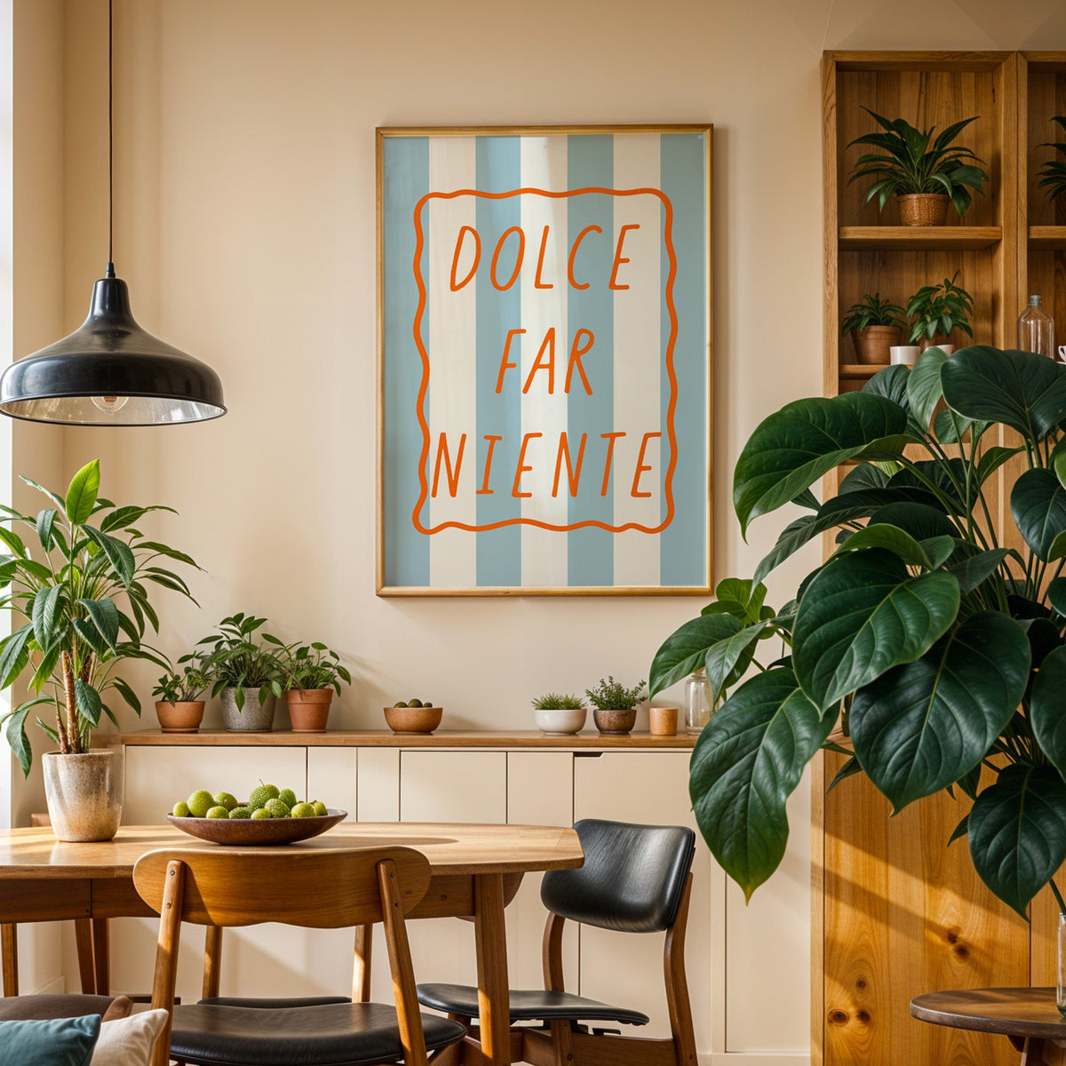 Dolce far niente print in an oak frame above a sideboard in a plant-filled dining room