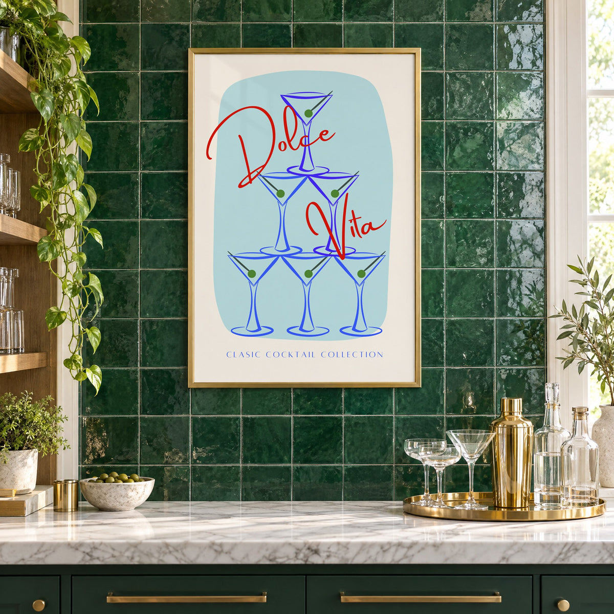 Dolce Vita martini tower print in a brass frame on emerald green tiles above a home bar with coupe glasses