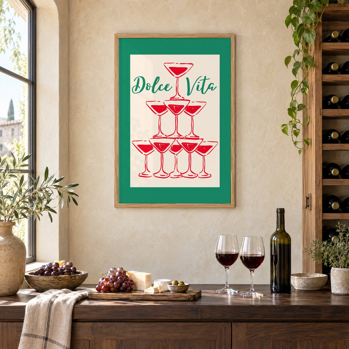 Dolce Vita red martini tower print in an oak frame on a limewashed wall above a wine counter with red wine, cheese and grapes