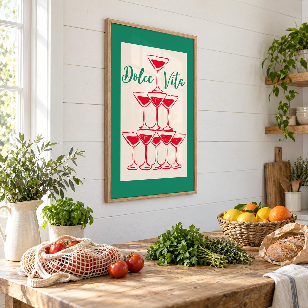 Dolce Vita red martini tower print in an oak frame on a shiplap wall above a farm table with market tomatoes and citrus, seen at an angle